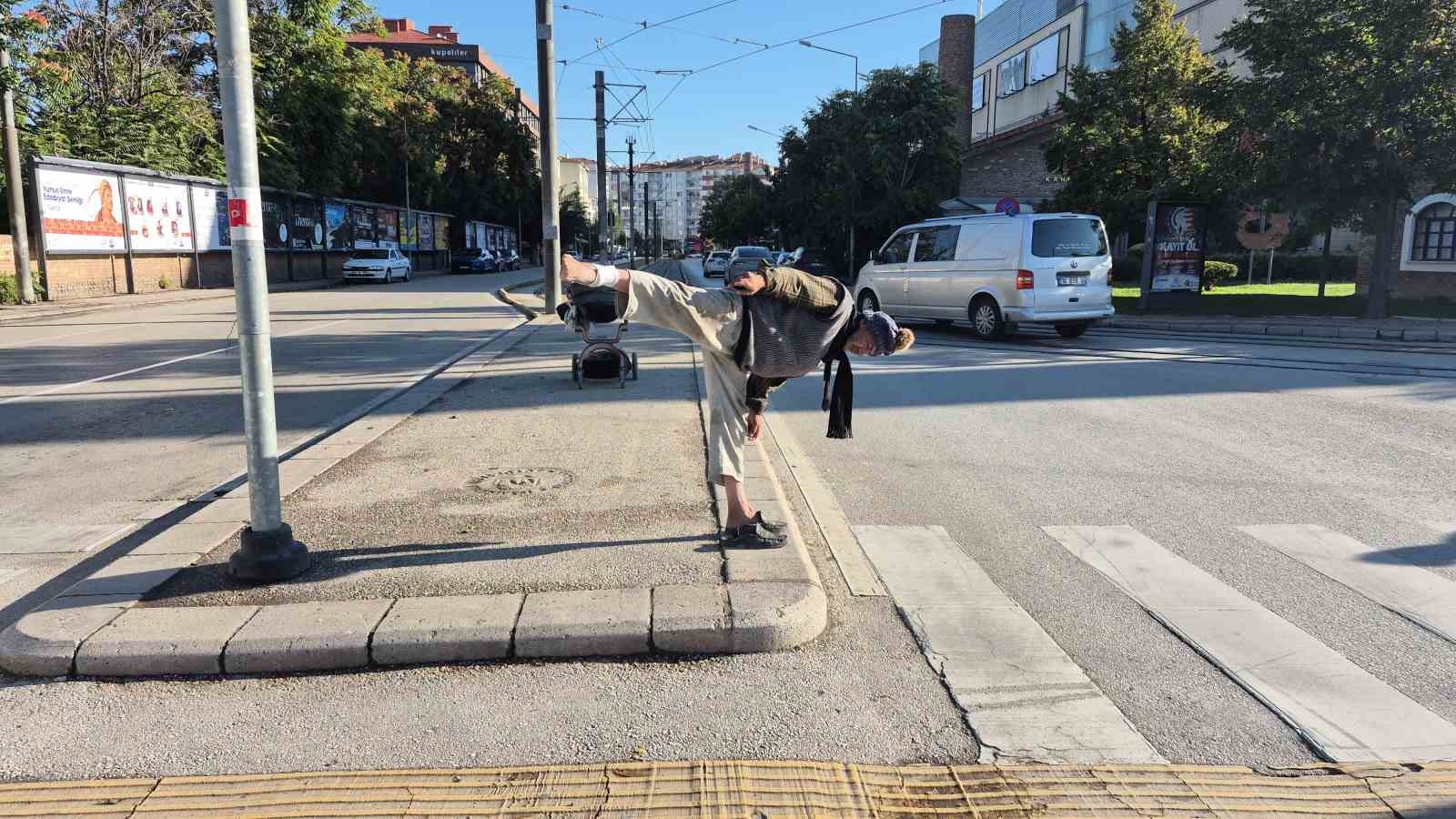 Sokak ortasında uzak doğu dövüş sanatı hareketleri yapan yaşlı adam